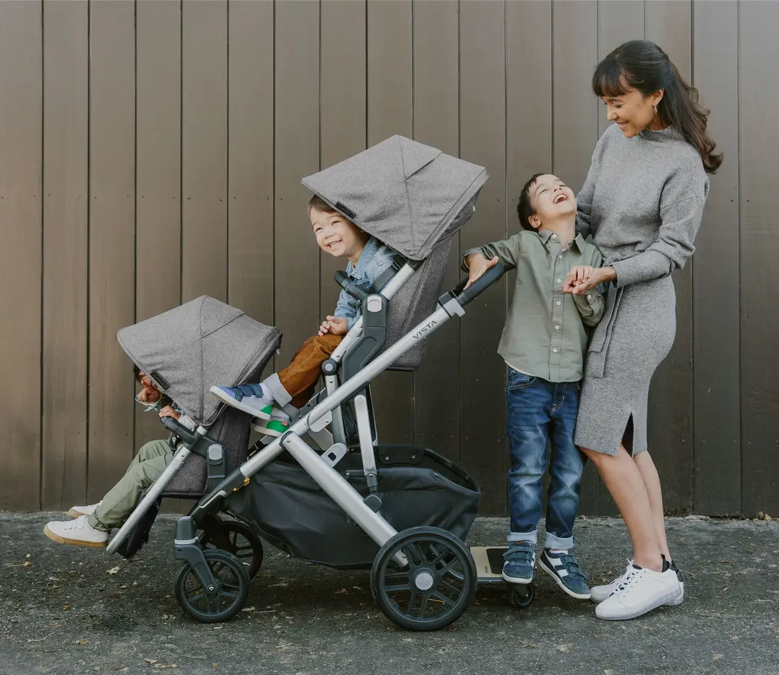 Una mamá y dos niños pasean con una carriola UPPAbaby Vista